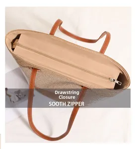 Close-up of the smooth zipper closure and beige lining of the straw woven tote bag
