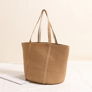 Minimalist straw tote bag with wide handles for summer beach vacations and daily use