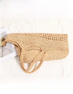 Detail shot of the beige hollow weave texture and foldable design on the straw tote bag