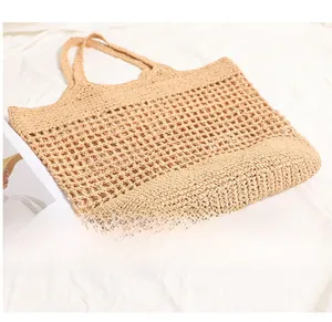 Detailed bottom view of woven beige straw tote bag showing intricate mesh pattern