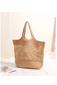 Detailed view of hollow woven straw tote bag with mesh texture for beach holidays