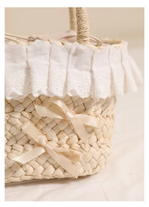 Close-up of handwoven straw bag featuring delicate lace edges and satin bow details