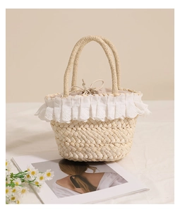 Close-up of woven straw handbag featuring delicate white lace trim and drawstring liner