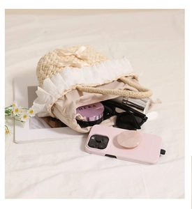 Detailed view of straw bag featuring delicate lace edges and a soft ribbon bow detail