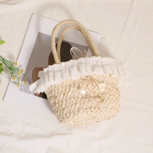 Straw handbag with white lace trim and ribbon bows for summer beach vacations