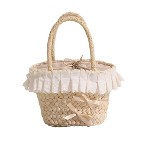 Straw handbag with white lace trim and satin bows for summer vacation beach trips