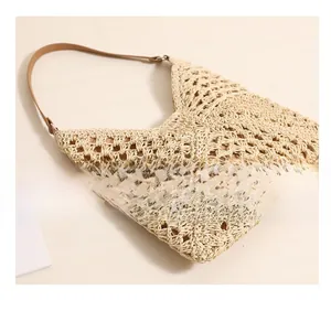 Detailed close-up of hollow-out woven texture and leather strap on a straw tote bag