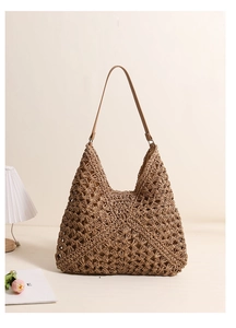 Detailed view of handmade hollow straw woven hobo bag with beige interior lining