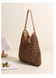Macro shot of brown hollow-out straw tote bag showing intricate handmade woven texture