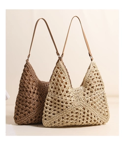 Detail of hollow woven straw tote bag featuring brown PU straps and contrast lining