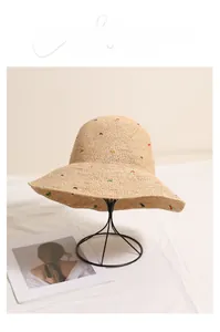 Détail macro du chapeau en raphia naturel avec pois colorés et texture tissée fine