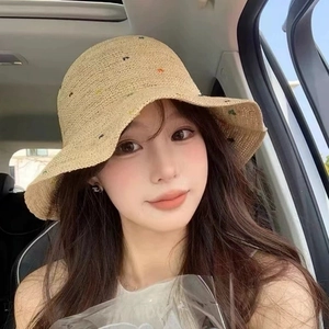 Gros plan d'un chapeau cloche en raphia léger avec motifs colorés et texture tissée fine