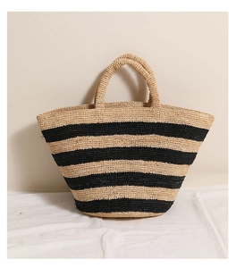 Close-up of a striped raffia tote bag with natural and black woven fibers for vacation
