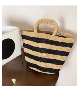 Detail of hand-woven striped raffia tote bag featuring large capacity and floral scarf