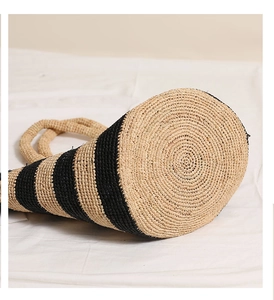 Detailed bottom view of striped raffia tote bag featuring spiral woven pattern