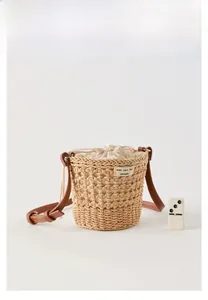 Détail du sac seau tressé en paille avec bandoulière en cuir et doublure en toile