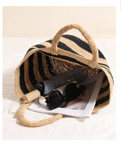 Detail view of striped raffia tote bag capacity with umbrella and sunglasses