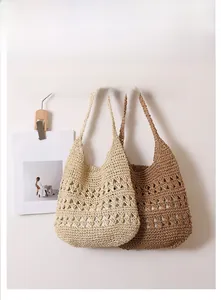 Detail of hollow out straw tote bag in cream and coffee brown colors for beach vacation
