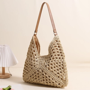 Minimalist straw tote bag with hollow woven texture and brown leather straps for beach holidays