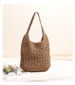 Detailed close-up showing the hollow mesh hand-woven texture of the straw tote bag