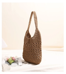 Close-up of hollow out woven pattern and texture on a natural straw beach tote bag