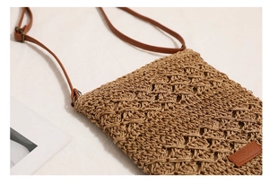 Detailed close-up of woven hollow mesh pattern and leather strap on a straw crossbody bag