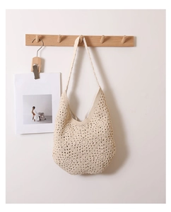 Détail du motif floral ajouré crocheté à la main sur un sac à bandoulière en coton beige