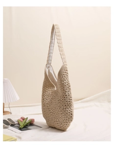 Gros plan détaillé du sac bandoulière au crochet beige avec des motifs ajourés tissés