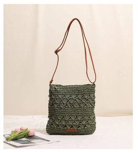 Close-up of green crochet woven bag with hollow texture and brown faux leather strap