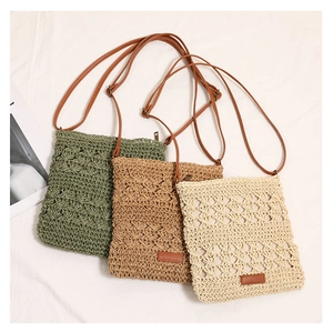 Detailed view of woven straw crossbody bags in green, khaki, and cream with adjustable straps