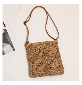 Detailed view of hollowed-out straw weave texture and brown leather patch on beach bag