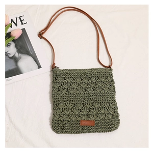 Detail of green straw crossbody bag with hollow wavy texture and brown shoulder strap