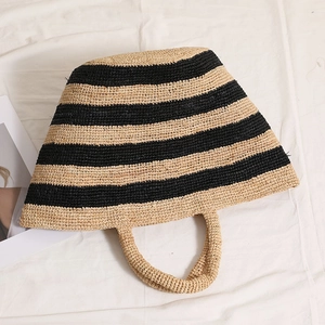 Handwoven raffia tote bag with black stripes and circular handle for summer beach holidays