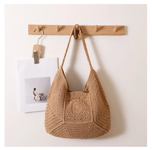 Detail of crochet tote bag with hollow flower pattern and bohemian cotton weave texture