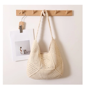 Close-up of bohemian hollow floral pattern on beige woven crochet beach tote bag