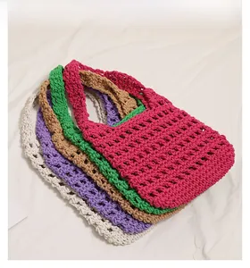Detail of multi-color hand-woven cotton beach bags in pink, green, and beige colors