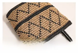 Detail shot of the geometric woven pattern and circular handles on a straw beach bag