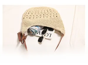 Detail view of large interior capacity of beige straw woven shoulder bag with accessories