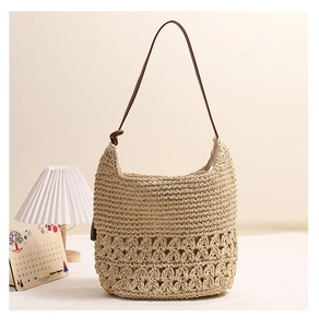 Detailed view of hollowed-out straw weave texture and slim brown leather shoulder strap