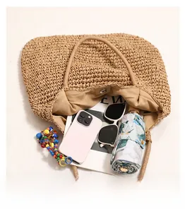 Detail view of large straw tote bag showing spacious interior with magnetic clasp