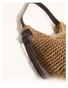 Dettaglio della trama in paglia intrecciata e tracolla in pelle con nodo decorativo