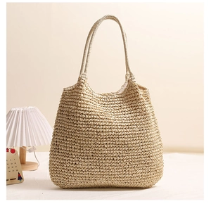 Close-up of the woven texture and handle of a beige straw tote bag for summer