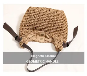 Dettaglio della grande borsa in paglia con tracolla in pelle e chiusura magnetica