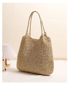 Detailed close-up of handmade crochet texture on a large natural straw tote beach bag