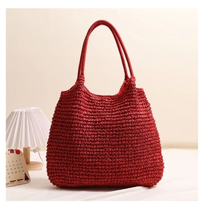 Close-up of red handmade woven tote bag with textured paper straw weave and dual handles