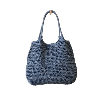 Blue woven straw tote bag with shoulder straps for beach vacation and summer outings