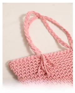 Detail of pink woven cotton handbag showing textured surface and fringe accents