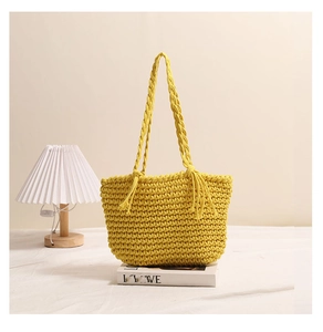 Detail of yellow hand-woven cotton tote bag featuring tassel accents and thick honeycomb texture
