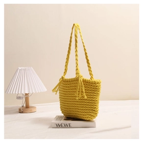 Close-up of yellow hand-woven cotton tote bag with tassel detail and diamond texture
