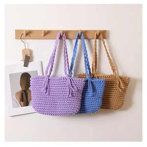 Detailed close-up of handmade crochet cotton tote bags with fringe and braided handles